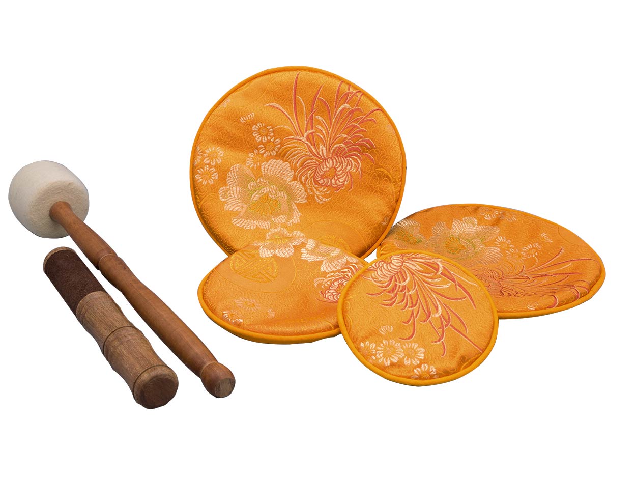 orangefarbene Pads mit Blumenmotiv, dazu ein Holz-Filz und ein Holz-Leder Klöppel