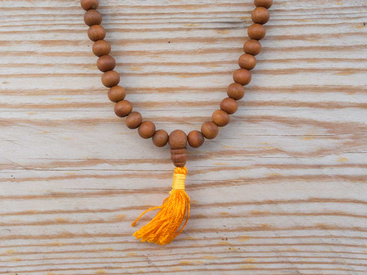 Mala aus Sandelholz, Detailaufnahme der Perlen und orangefarbene Quaste